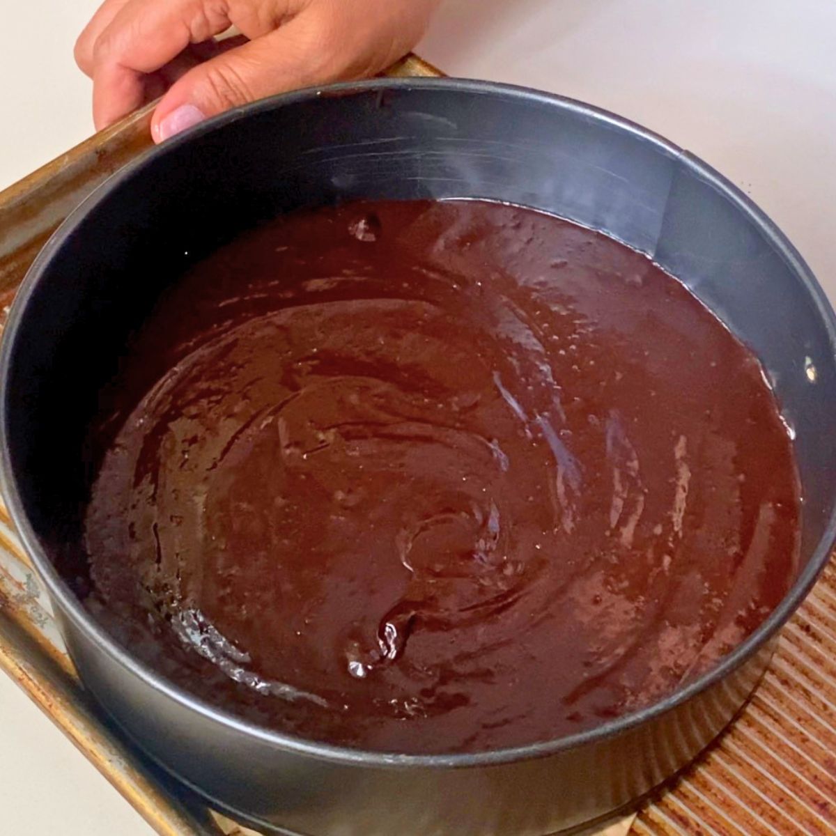 Chocolate brownie in a spring form pan for baking.