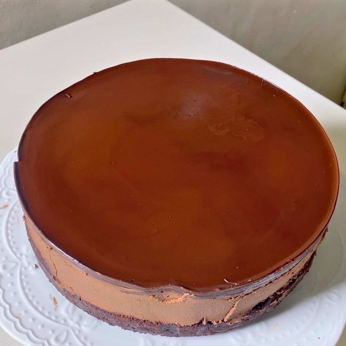 A cake stand with unmolded chocolate mousse cake.
