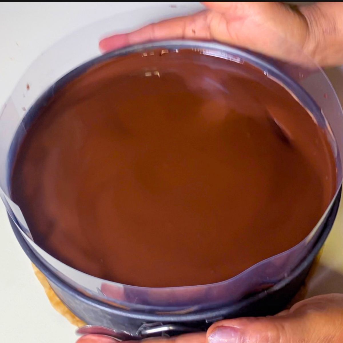 Adding glaze to the chocolate mousse cake.