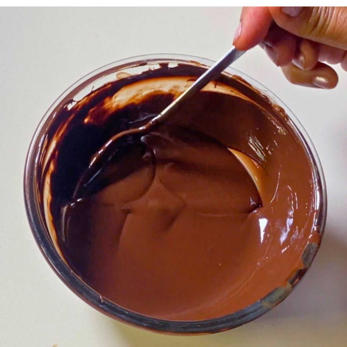 Chocolate glaze in a glass bowl.