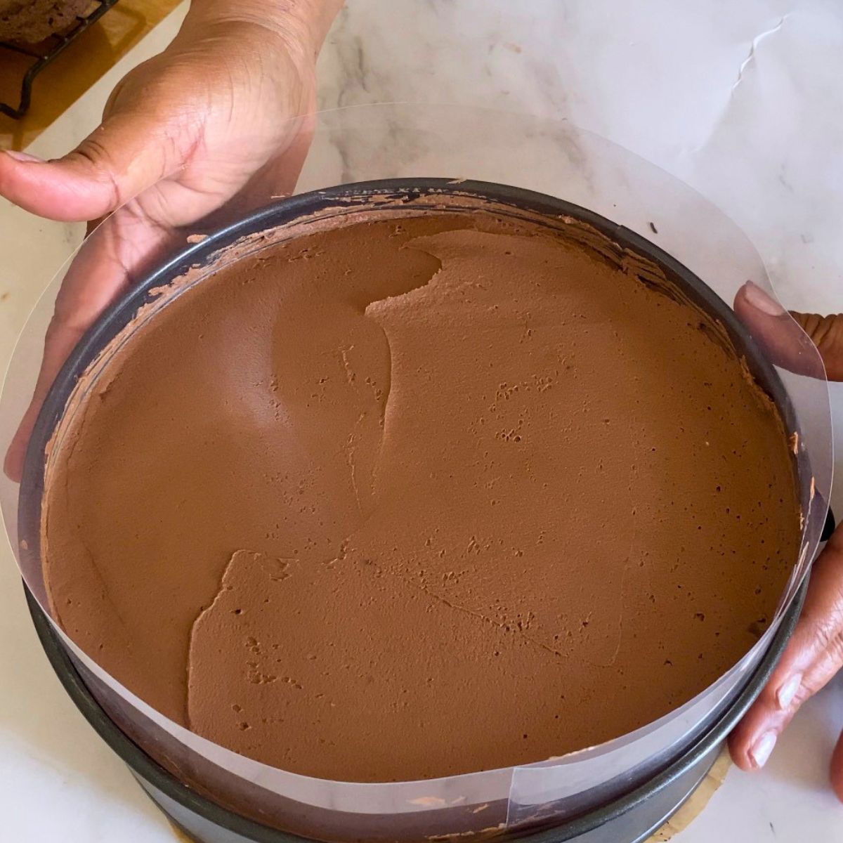Smoothing the chocolate mousse in a spring form pan.