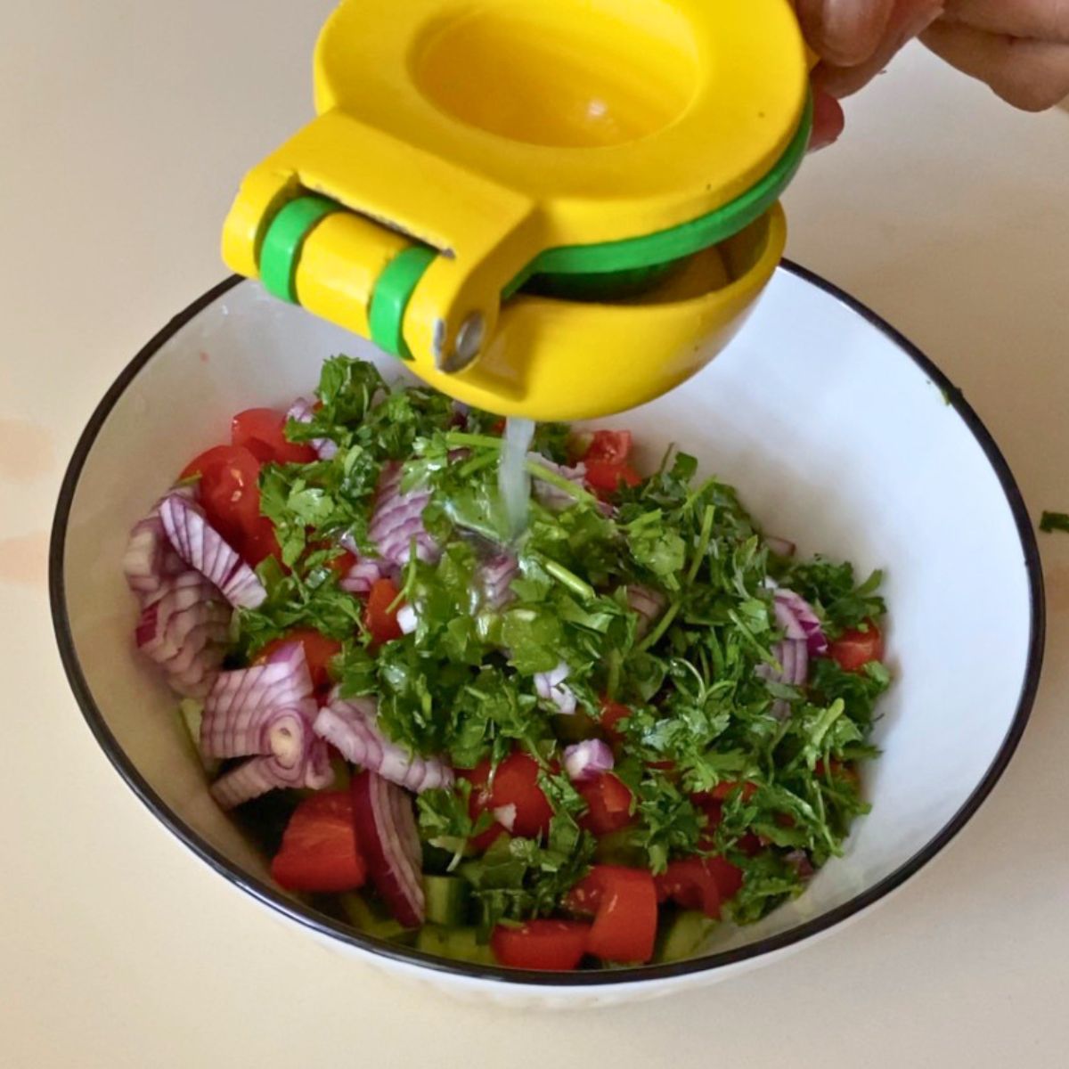 Adding Lemon and Olive oil to the chopped salad.