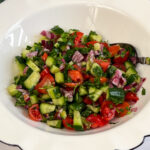A white bowl with chopped Israeli Salad.