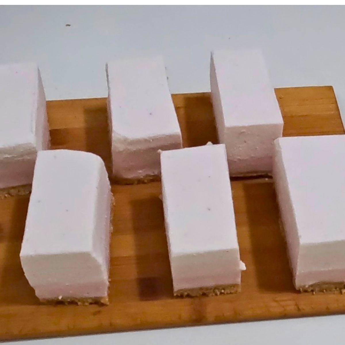 A wooden board with 8 mousse slices.