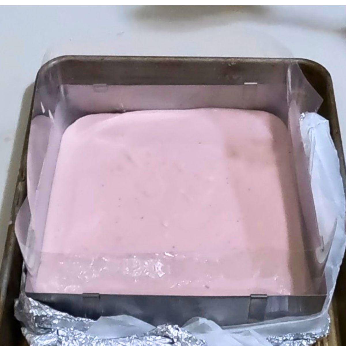 A baking pan with a layer of strawberry mousse.