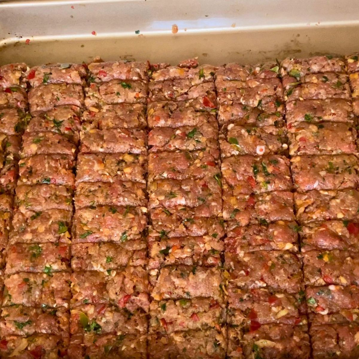 Spread ground beef on the sheet pan to make kebabs.