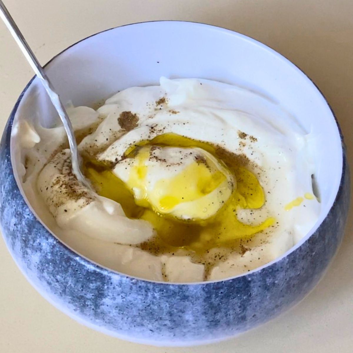 A bowl with Greek yogurt and ingredients.
