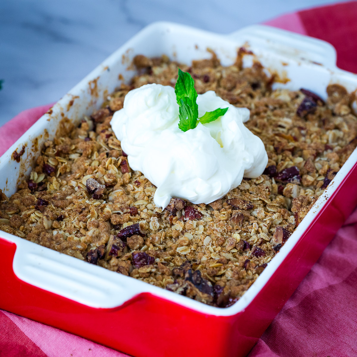 A red baking dish with peach crisp.