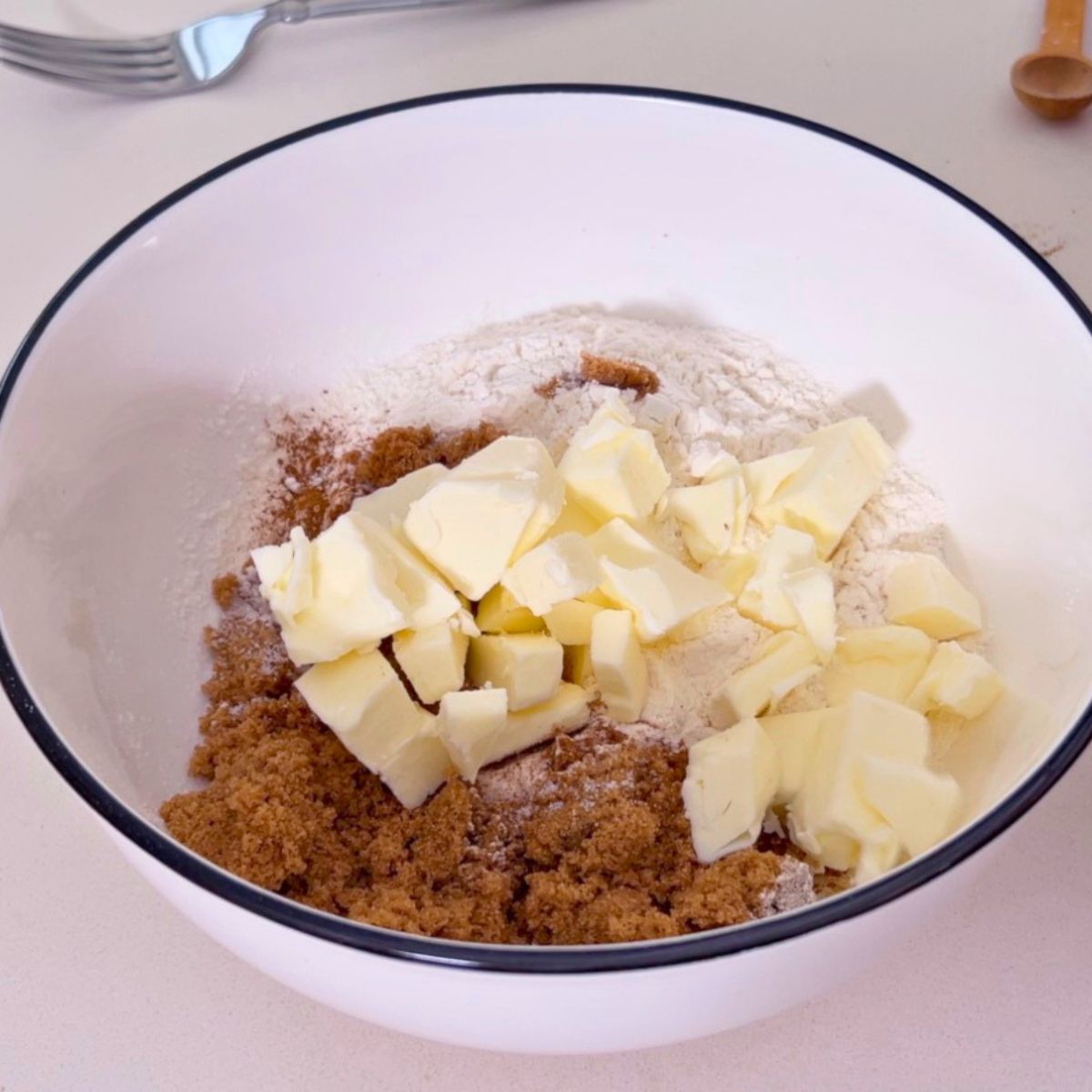 A white bowl with streusel and cold butter.