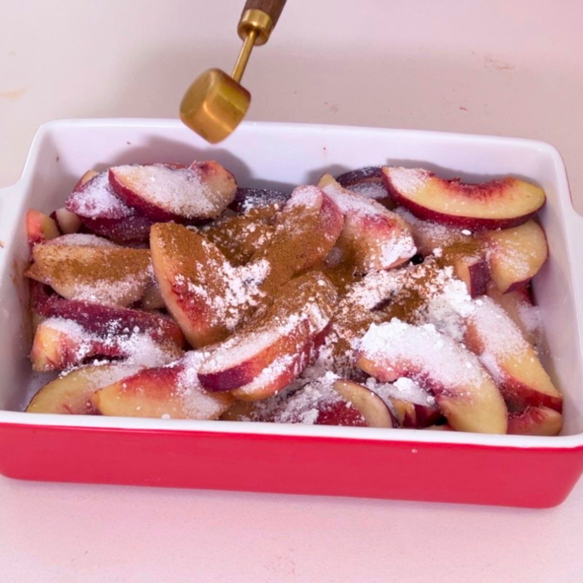 A baking dish with fresh peach mixture for crisp.