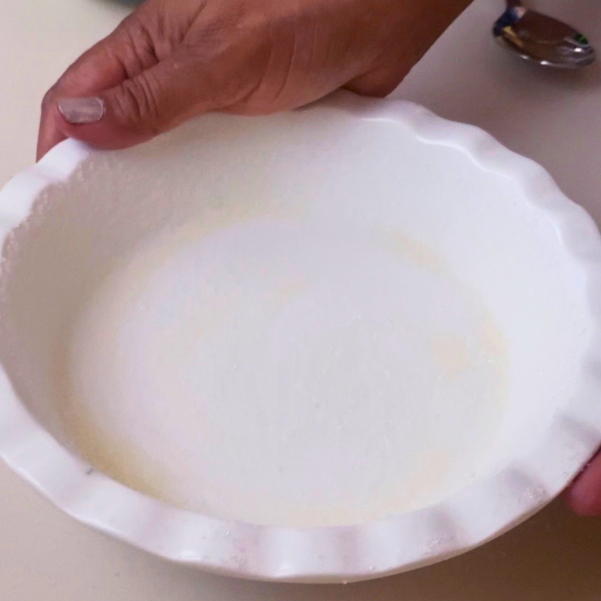 A pie pan buttered and dusted with granulated sugar.
