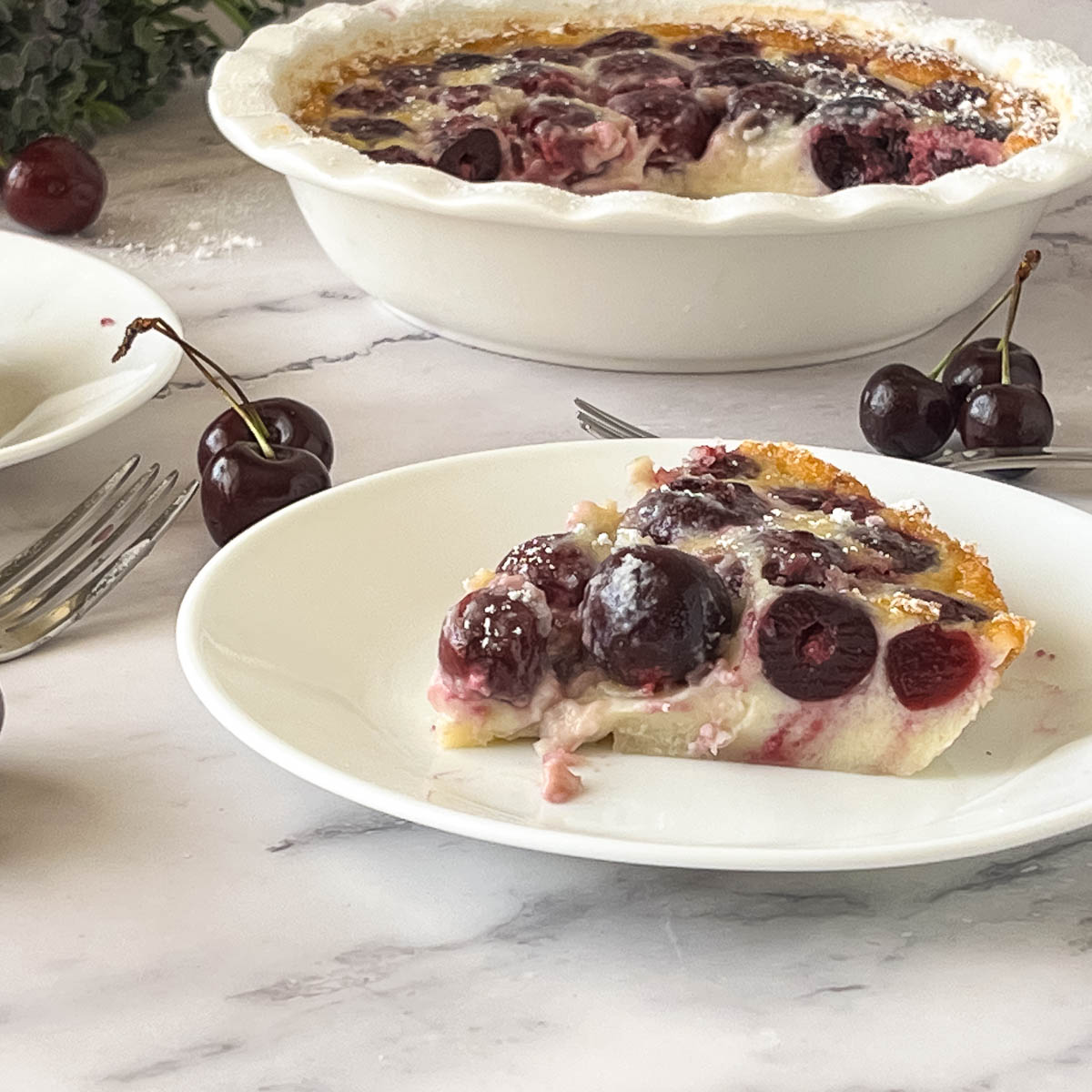 A slice of cherry clafoutis on a plate.