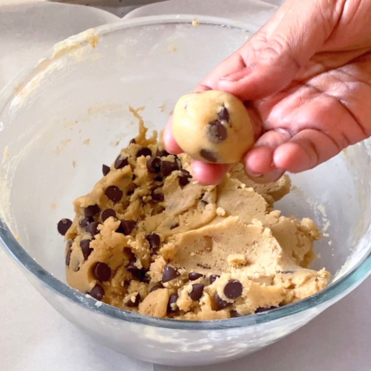 Shaping tahini cookie balls for baking.