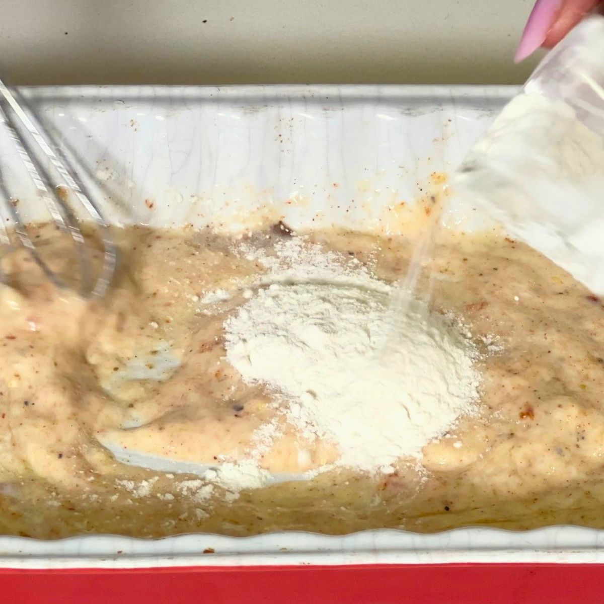 Making the egg batter for chicken breast.