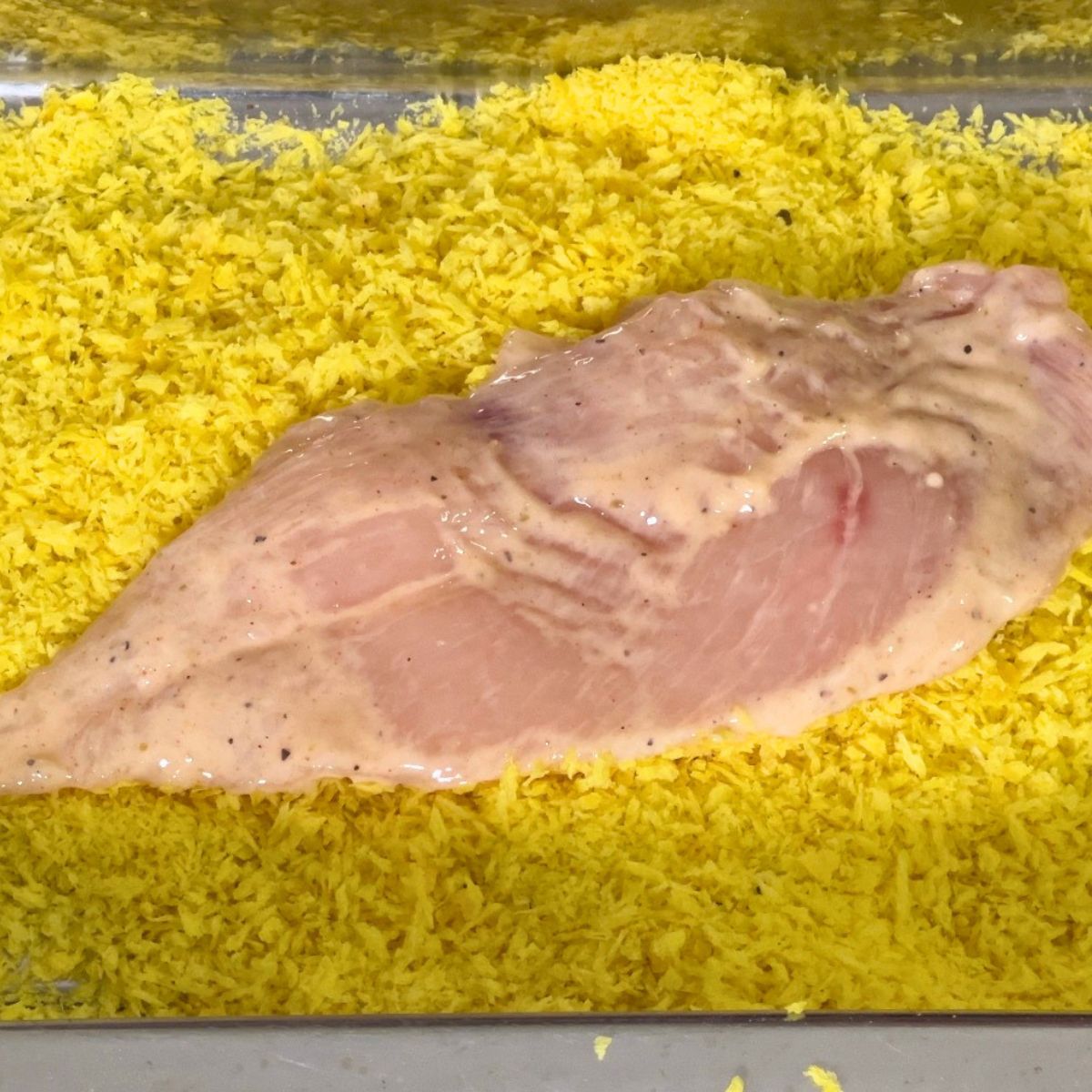 Coating the chicken breast with panko crumbs.