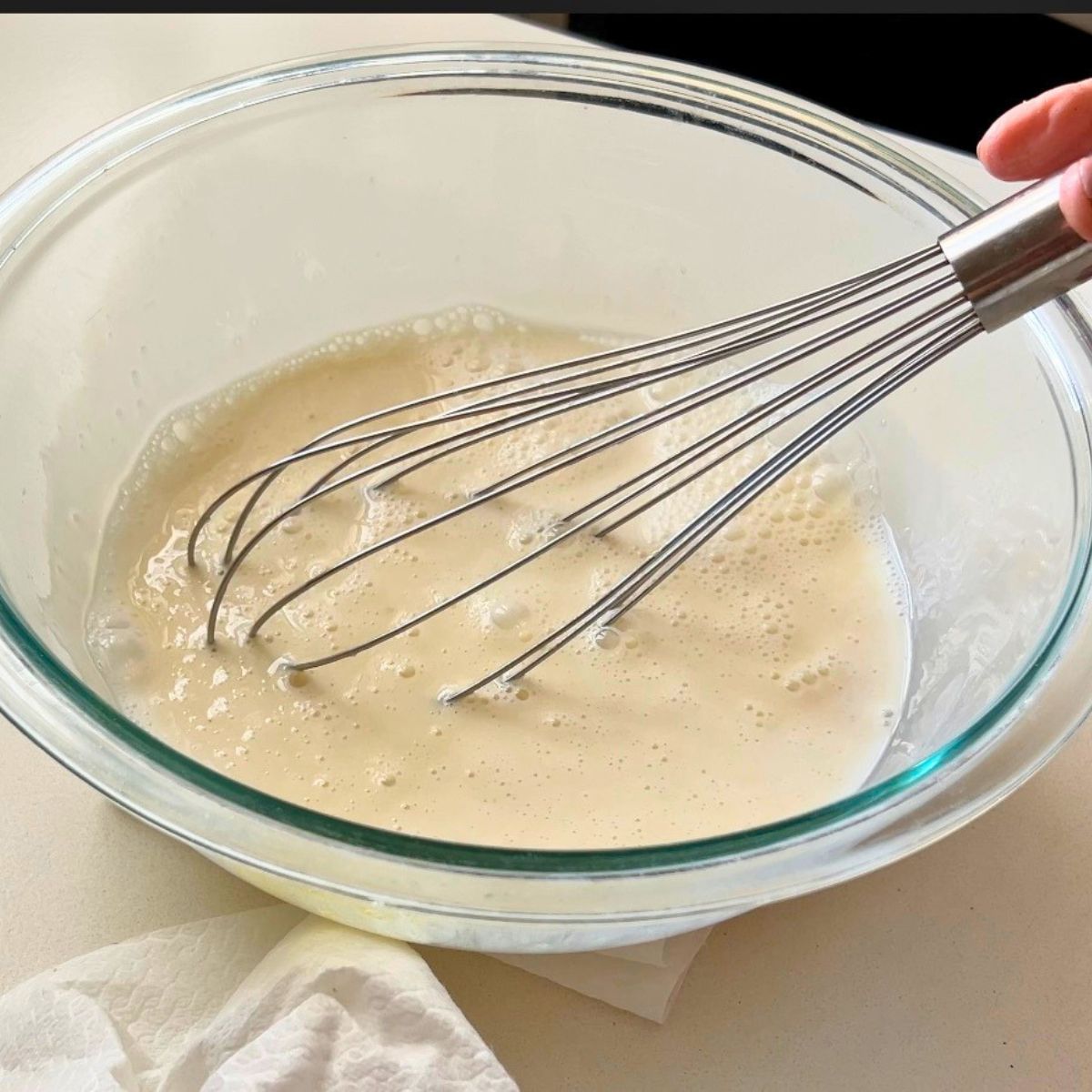 A bowl with wet ingredients for waffles.