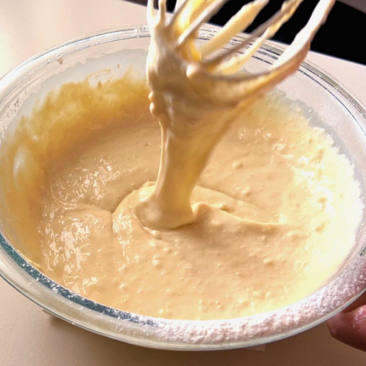 A glass bowl with fresh waffle batter.