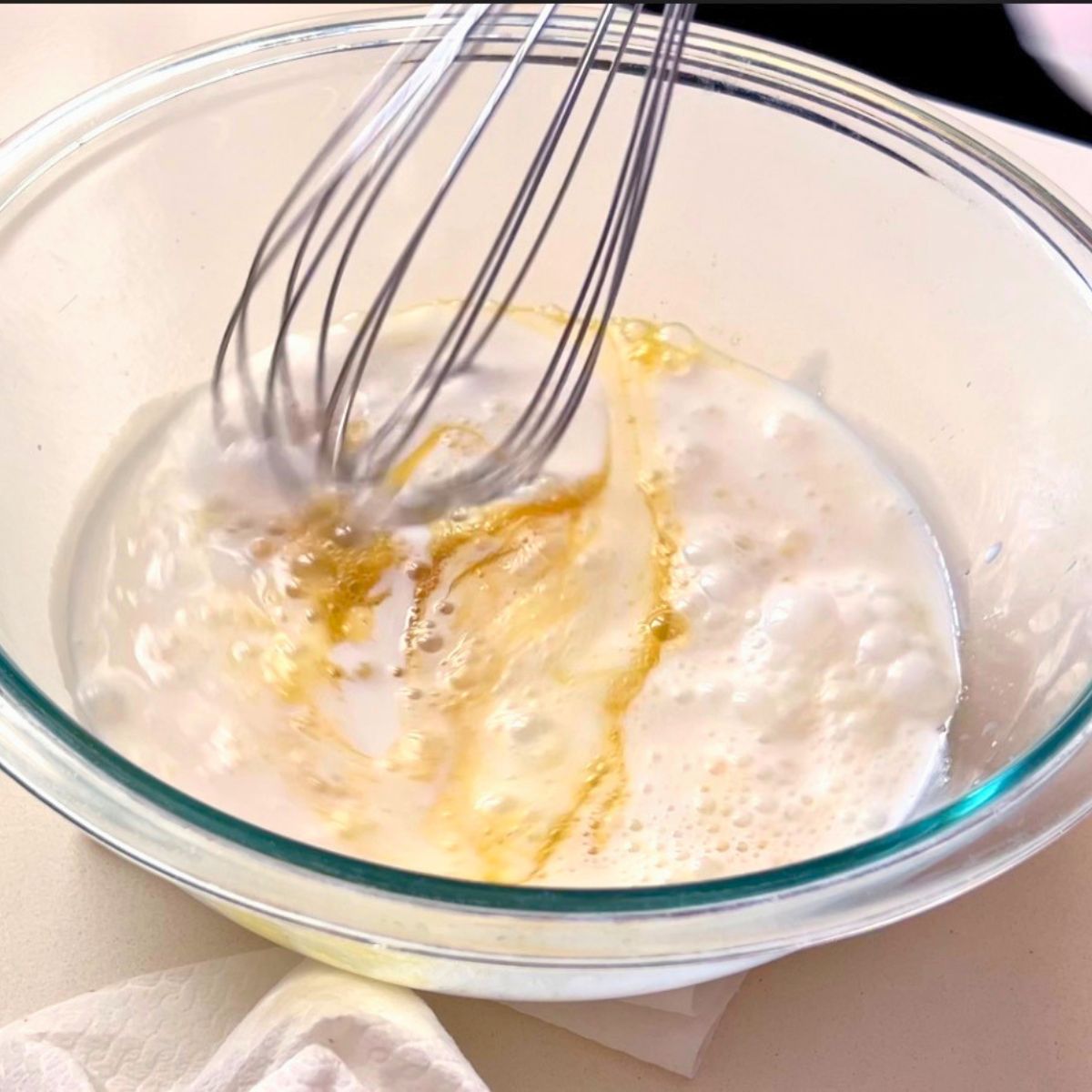 Adding milk to the waffle batter.