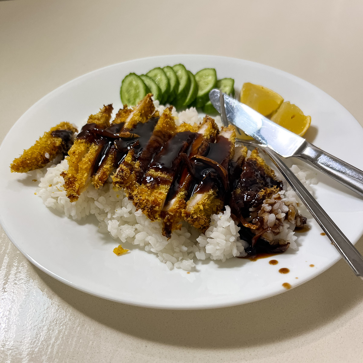 A plate with crispy baked chicken breast and balsamic glaze.