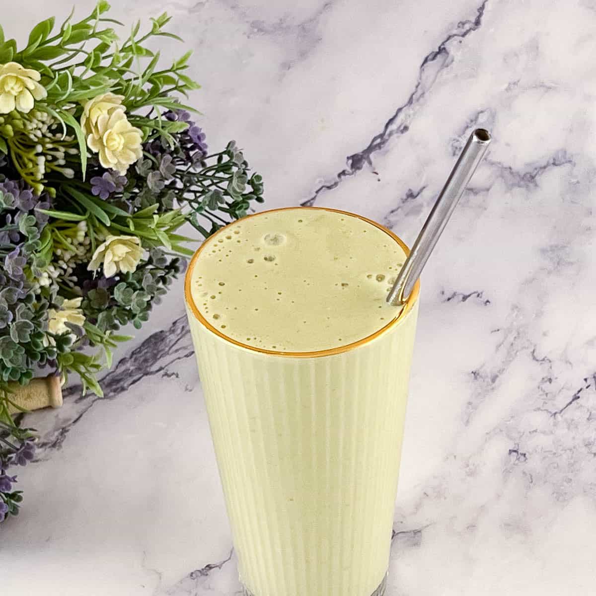 A tall glass with matcha smoothie.