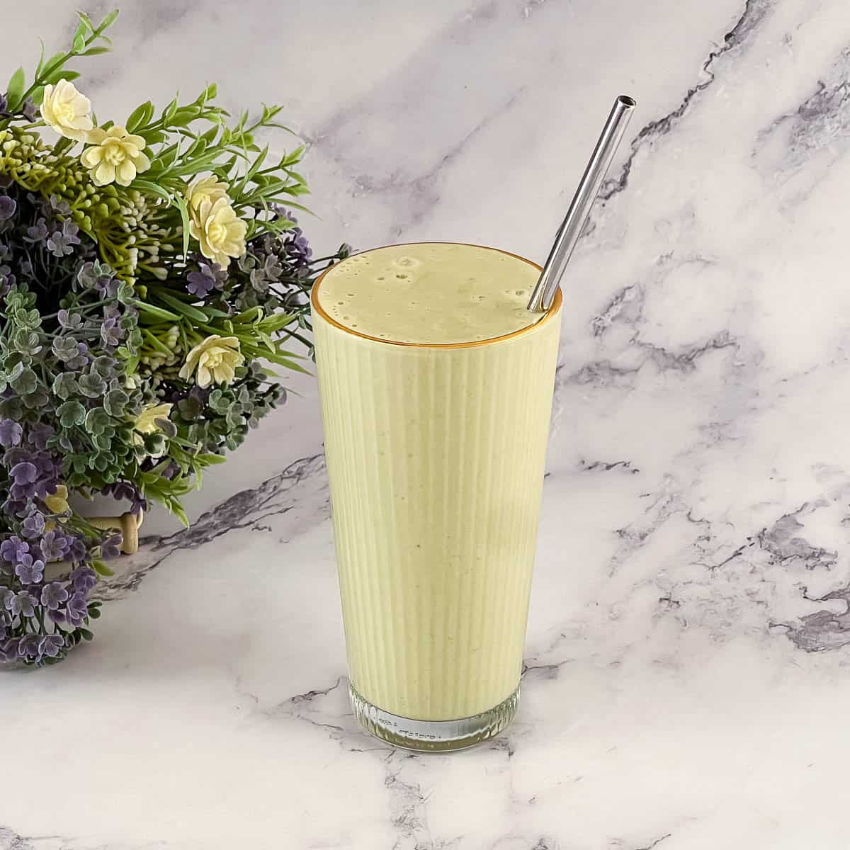 A tall glass with matcha smoothie.