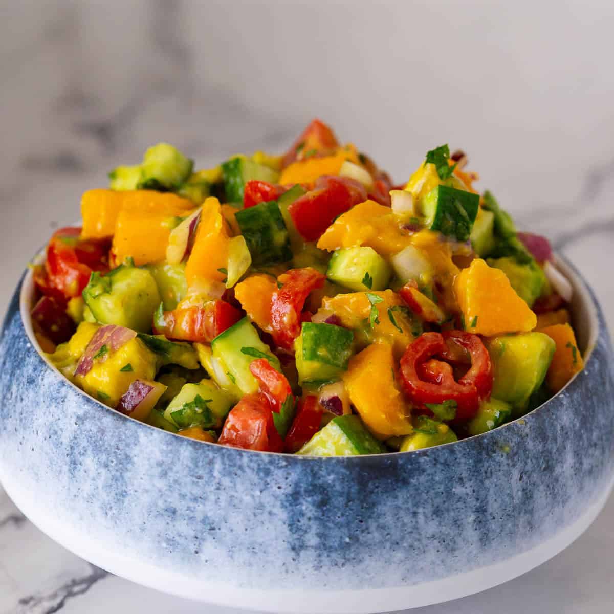 A bowl with mango salad recipe.