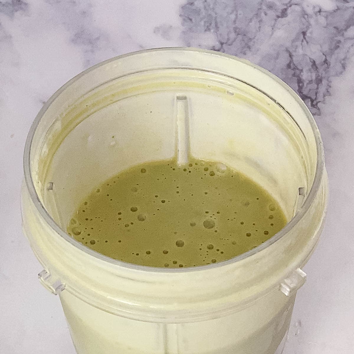 A blender with matcha smoothie.