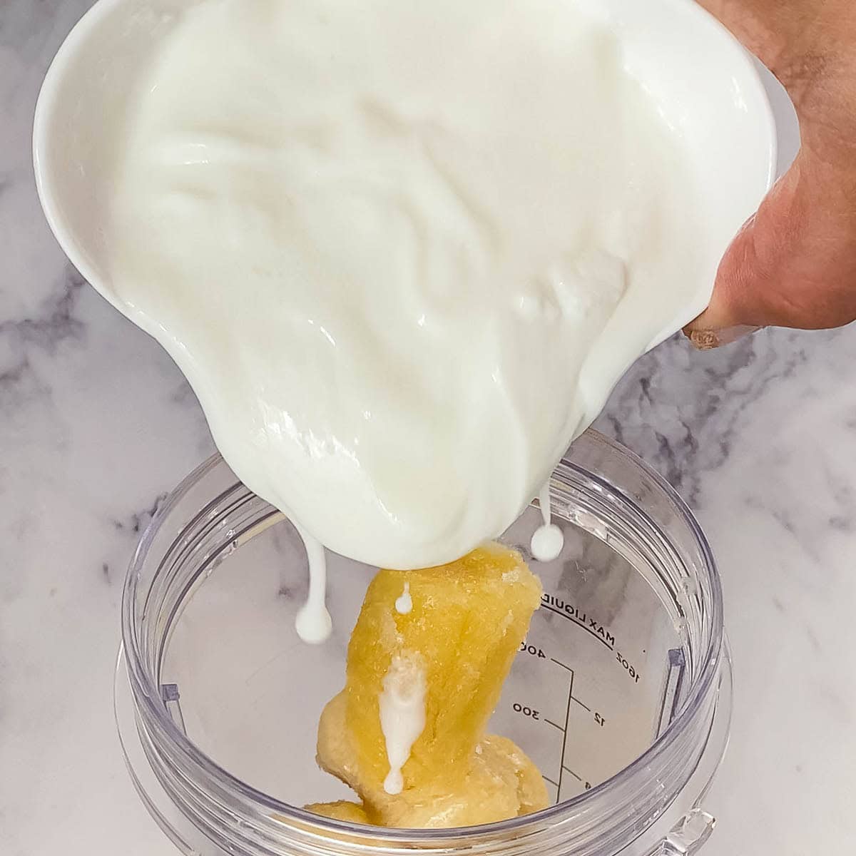 Adding yogurt to the blender.