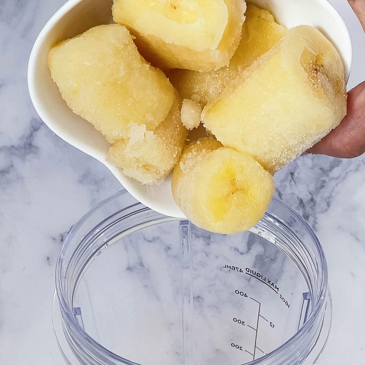 Adding banana to the blender.