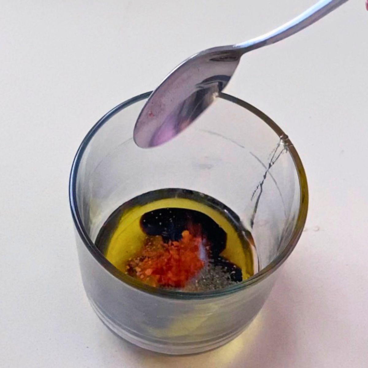 A glass with balsamic dressing.
