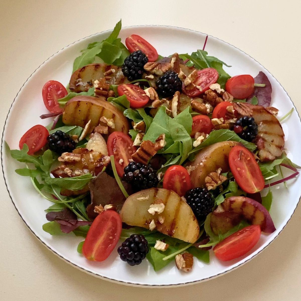A fresh salad with grilled peaches.