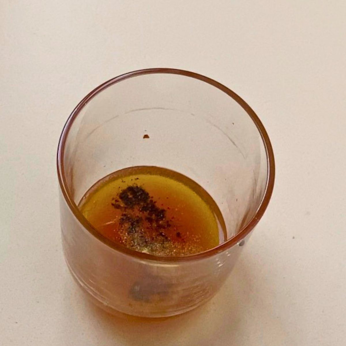 A mini cup with vinegrate dressing.