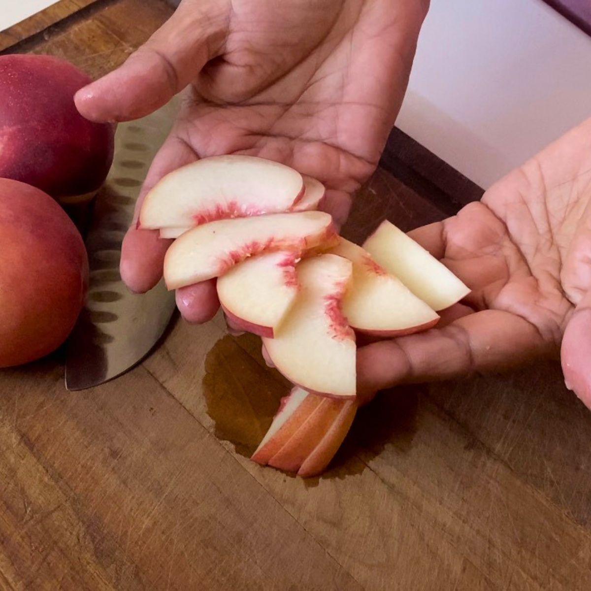 Sliced fresh peaches on the board.
