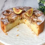 An almond cake with fresh figs on cake stand.