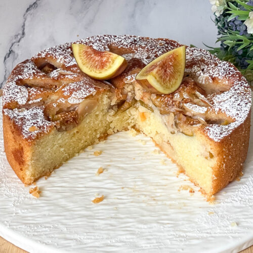 An almond cake with fresh figs on cake stand.