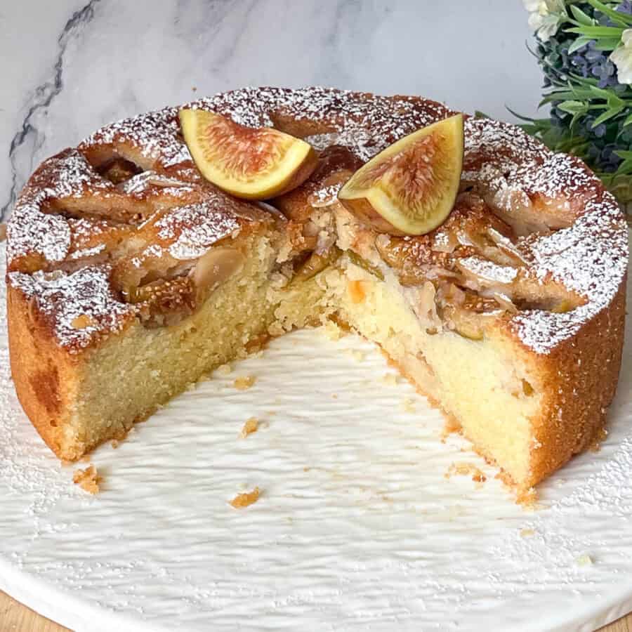 An almond cake with fresh figs on cake stand.