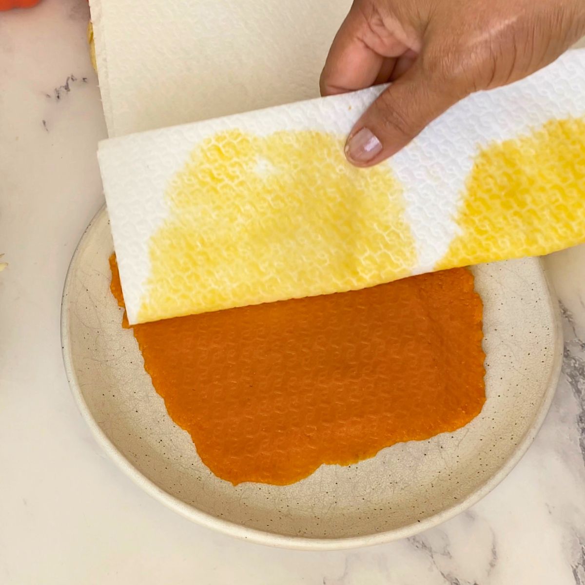 Pumpkin puree on a plate blotted with pumpkin puree.