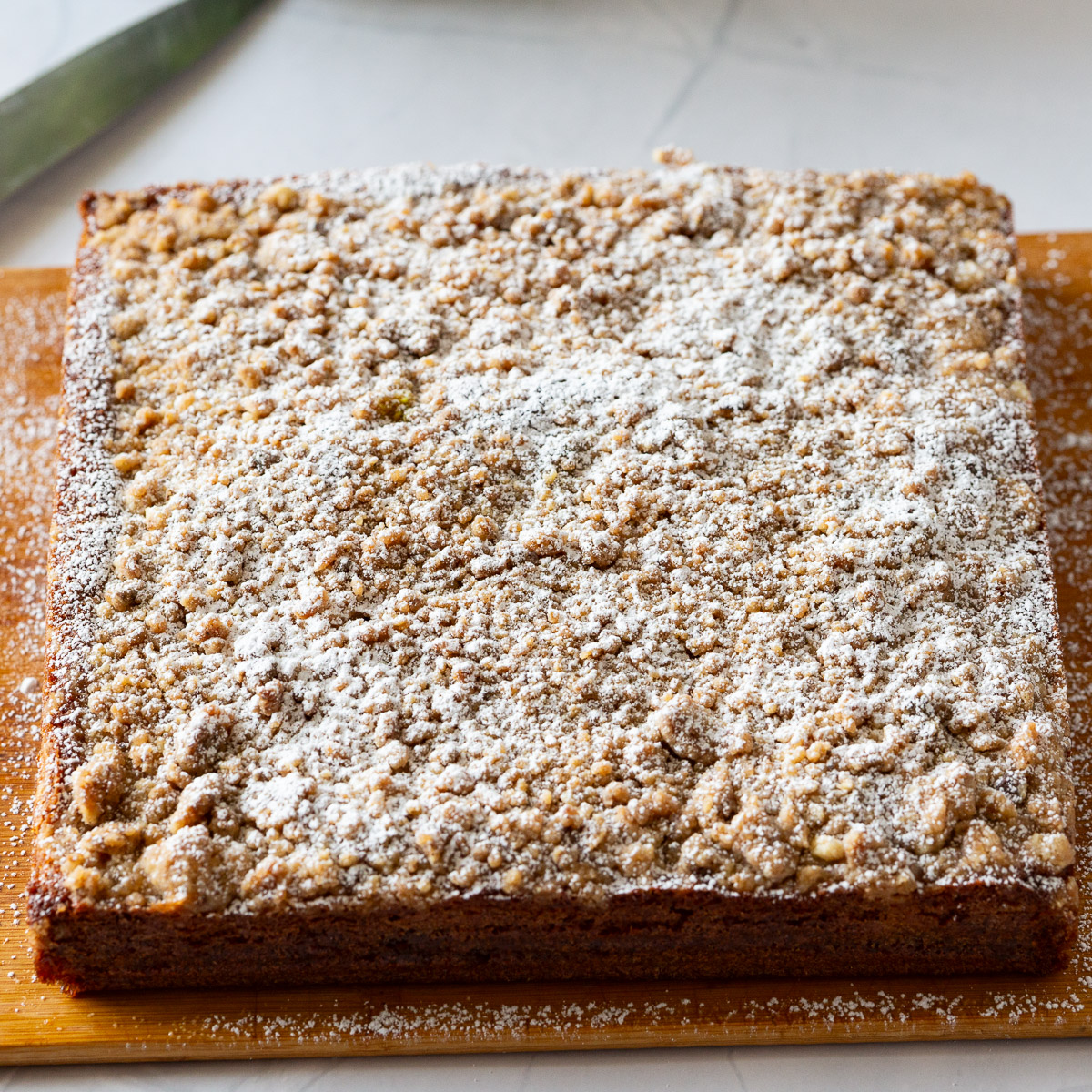 A coffee cake with streusel on the wooden board.