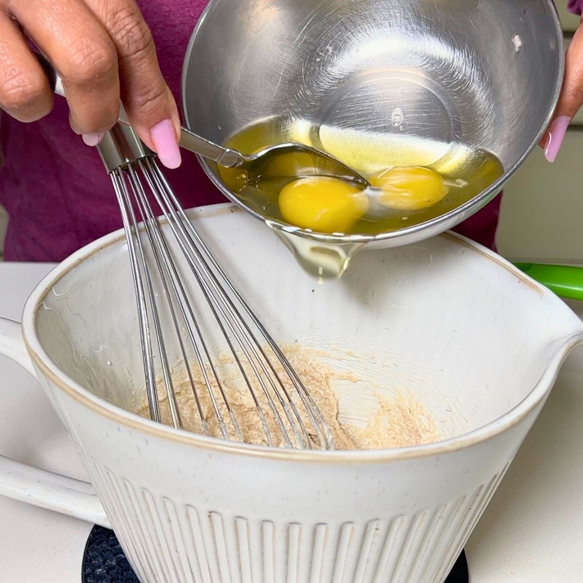 Adding eggs to the cake batter.