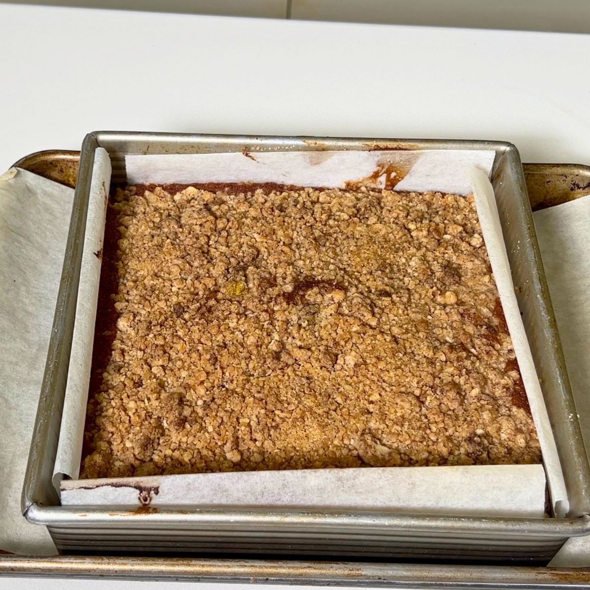 Baked coffee cake with streusel in a baking pan.