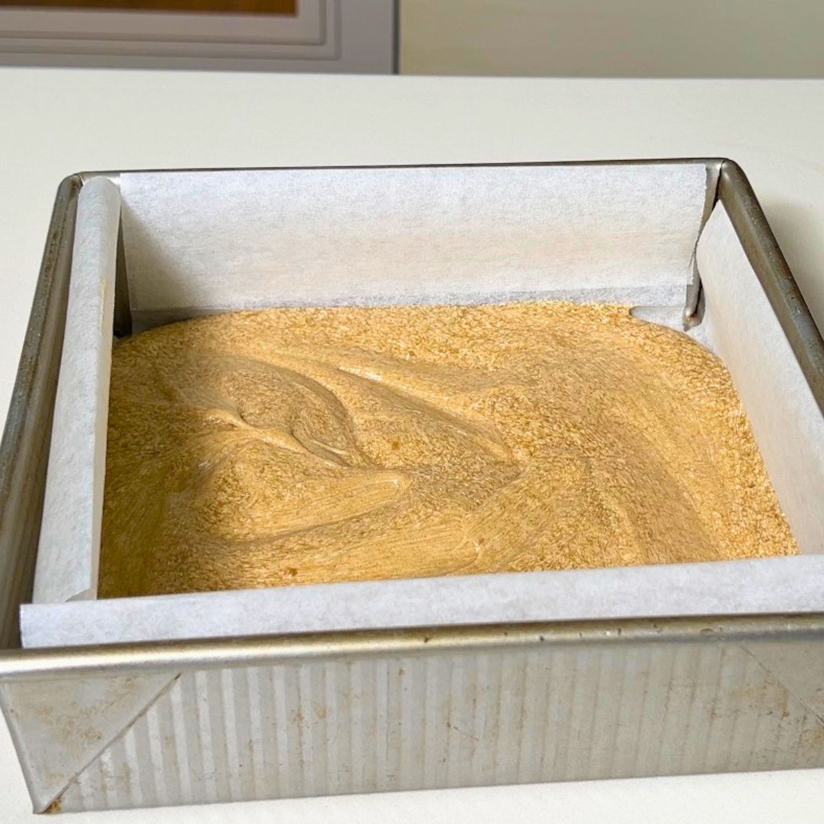 A square pan with coffee cake batter.