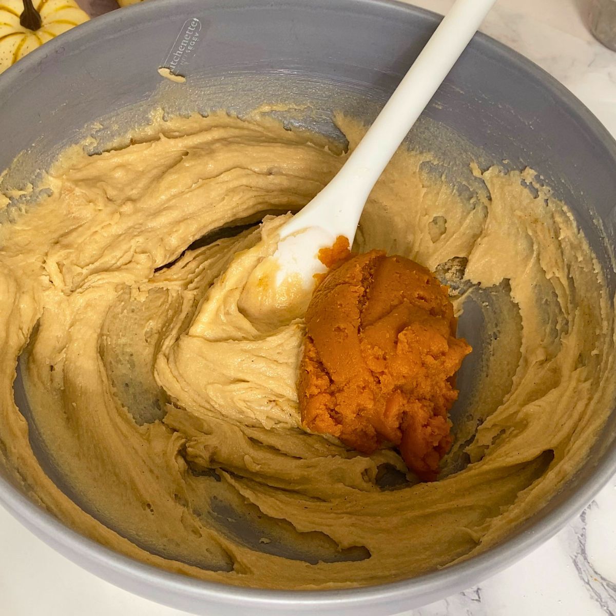 Adding pumpkin puree to the cookie dough.