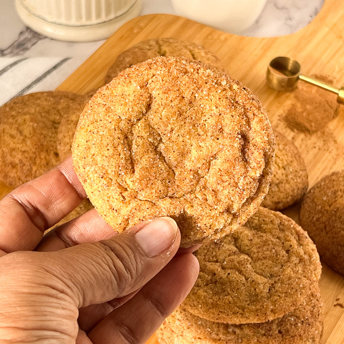 A hand holding pumpkin cookie.