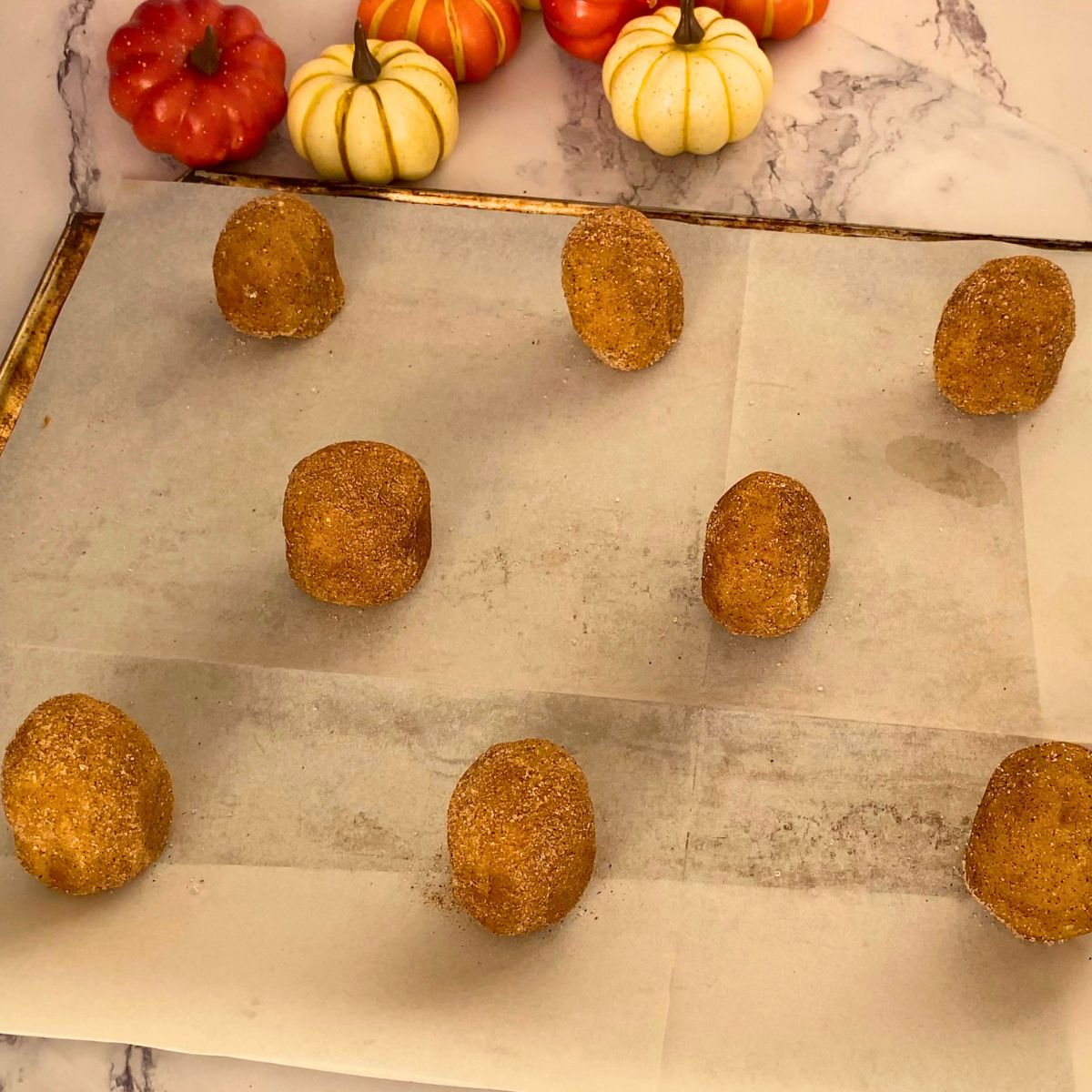 Tall cookie dough balls on a baking tray for baking.