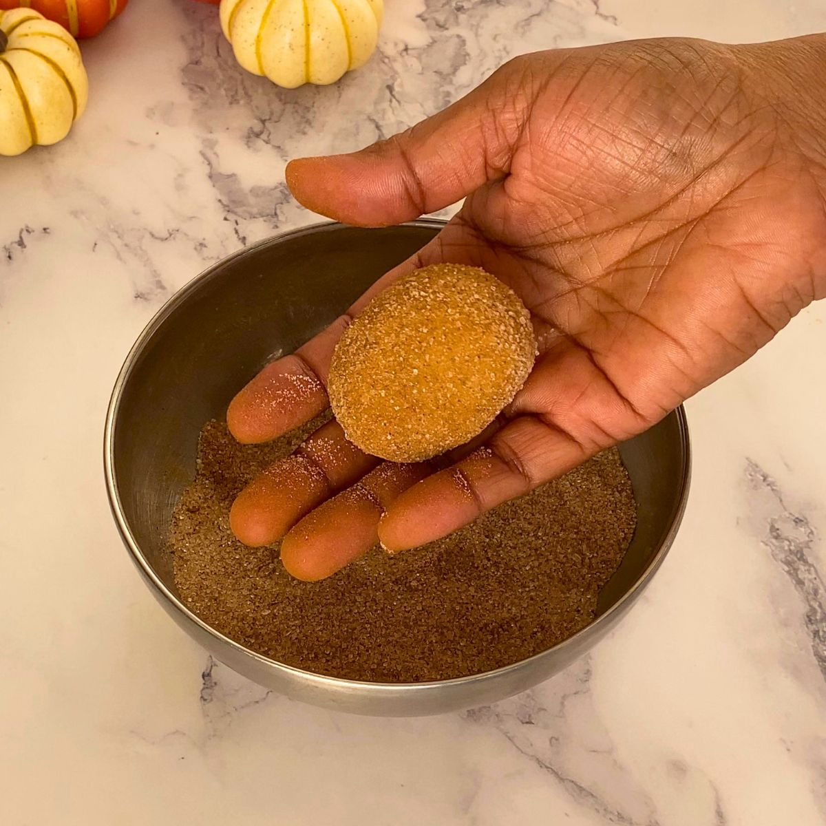 A snickerdoodle cooke ball coated with cinnamon sugar.