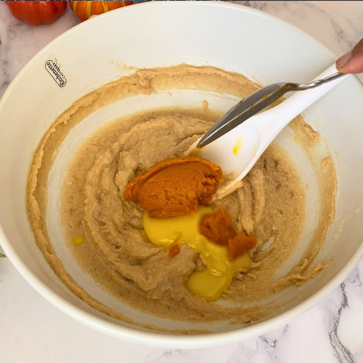 Adding pumpkin puree to the cookie dough.