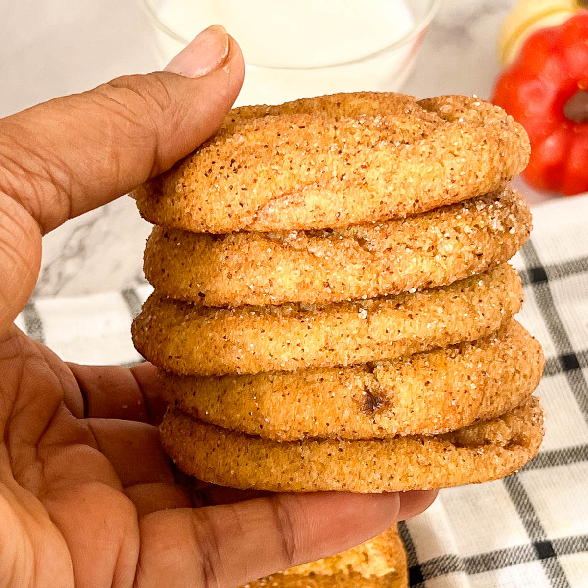 Holding a stack of cookies on the table.