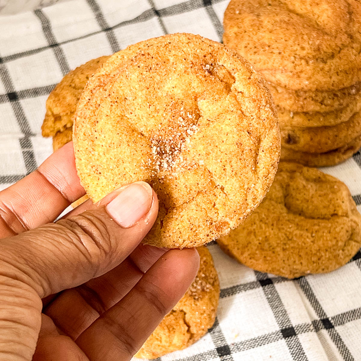 Two fingers holding a cookie.