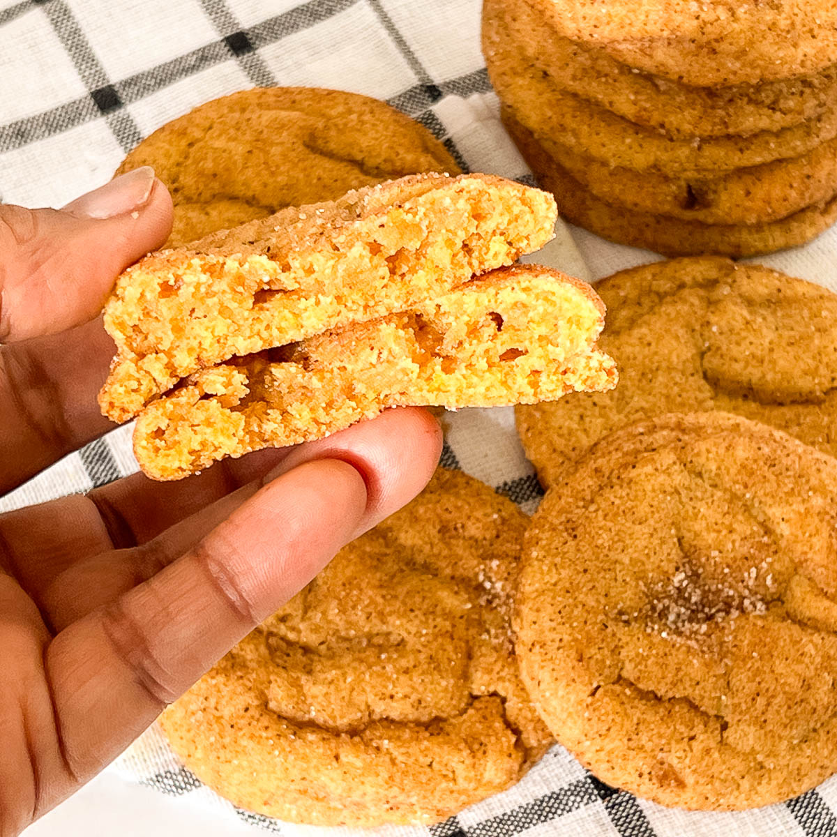 Holding pumpkin snickerdoodle cookies on the table.