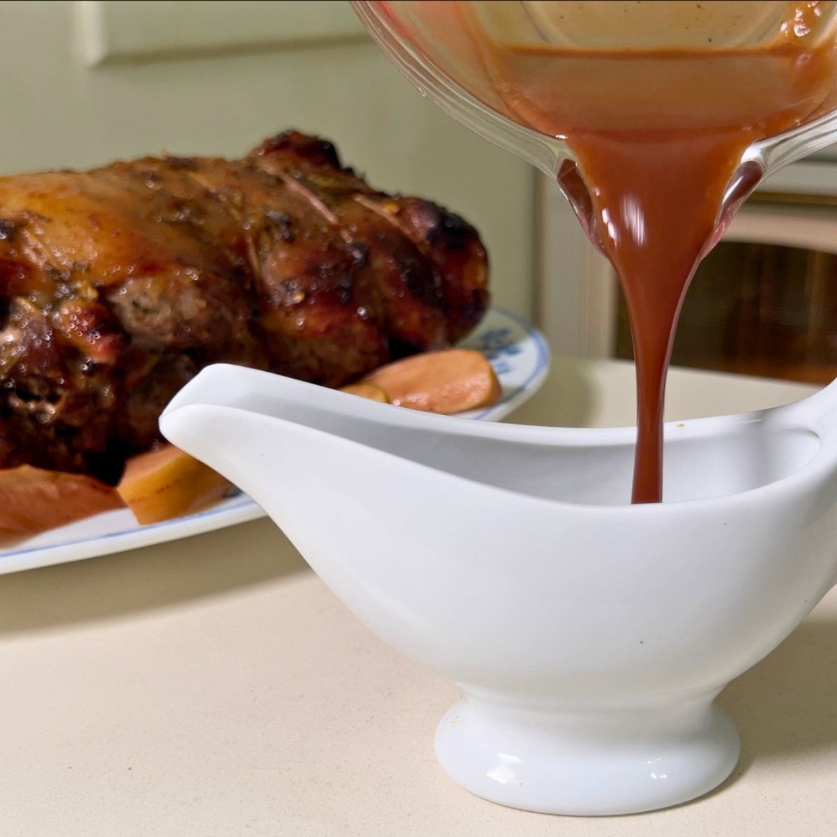 Pouring gravy into a sauce boat.